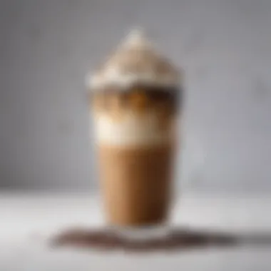 A close-up of a deliciously frothy iced coffee topped with whipped cream and chocolate drizzle